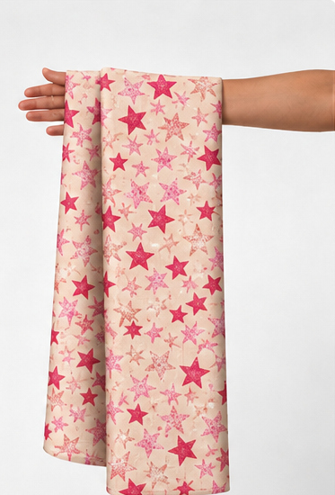 Rose Pink Star Print poly-cotton held in hand for scale