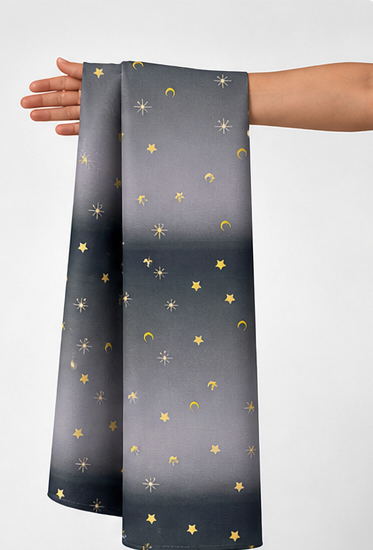 Charcoal Golden Star Dust poly-cotton held in hand for scale