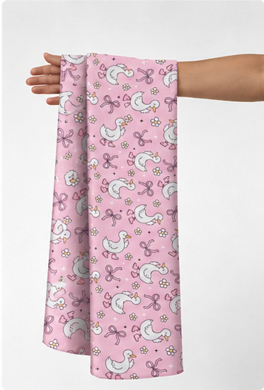 Pink Whimsical Unicorns poly-cotton held in hand for scale