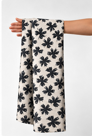 Ivory Black Bold Leaf Print poly-cotton held in hand for scale